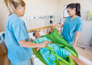 Imagen de auxiliares de enfermería moviendo a un paciente